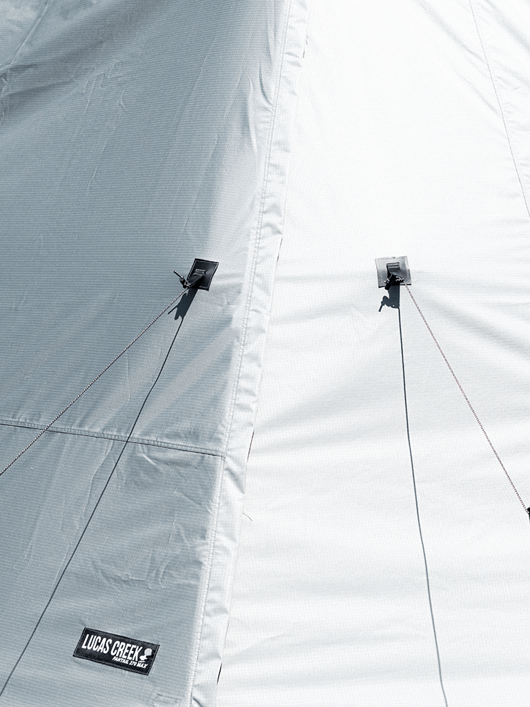 Close up shop of the Lucas Creek 180 Fantail free standing awning showing the tie down points to allow the wall kit to keep its shape 